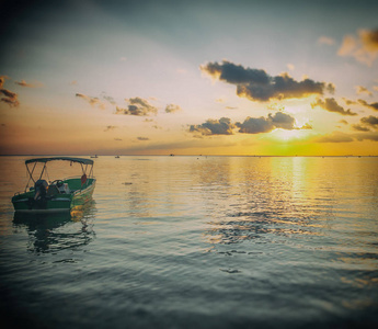 在海水拍打明亮美丽的夕阳和红船。旅行