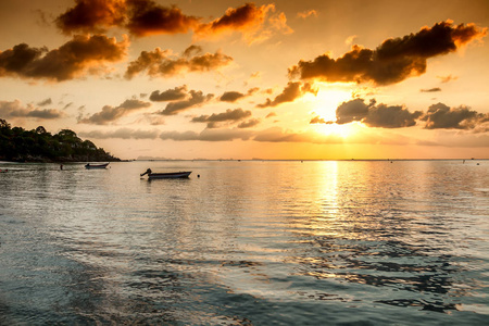 在海水拍打明亮美丽的夕阳和红船。旅行