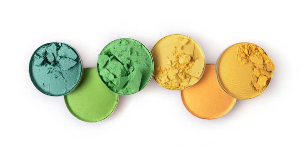 圆的黄色和绿色坠毁的眼影化妆美容产品的样品作为