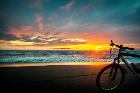 日落时海边的旅游自行车照片