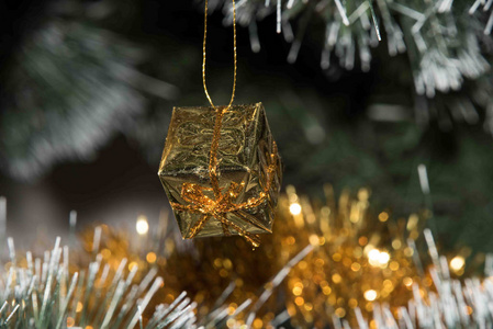 出席新年分店。金色的圣诞装饰品。特写。圣诞树灯背景礼品盒