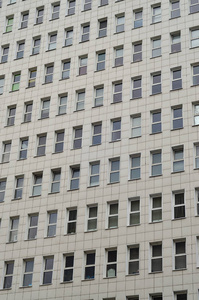 多层办公楼的许多窗户的图案。一栋现代化的多层建筑的墙上有大量的塑钢窗
