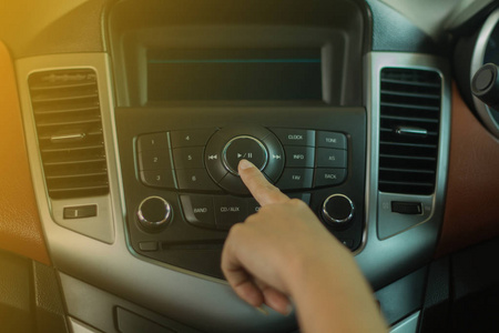 妇女在车上的收音机上按按钮