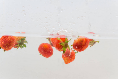 一组草莓溅在清水新鲜草莓果中
