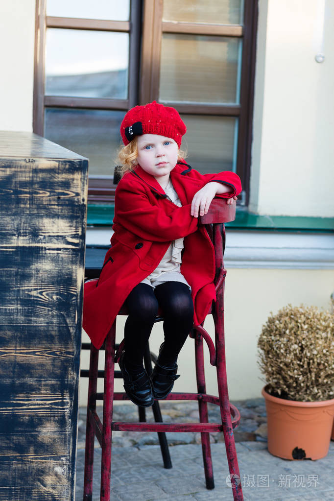 漂亮的小女孩穿着红外套的红头发的画像