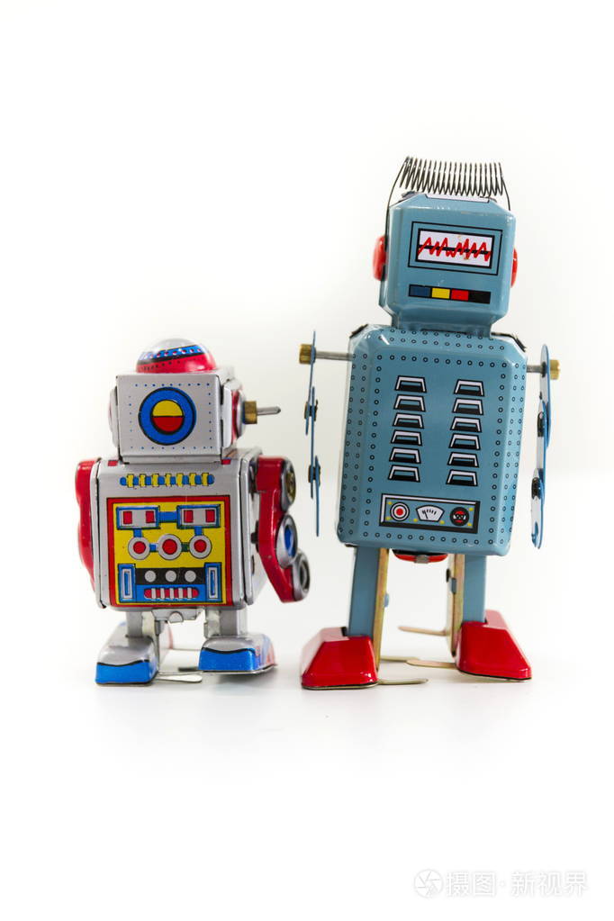 孤立在白色背景上的两个老式的铁皮玩具机器人