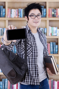 男学生在图书馆里显示智能手机