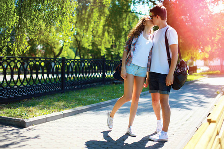 年轻夫妇爱情接吻在夏天菽城市公园散步