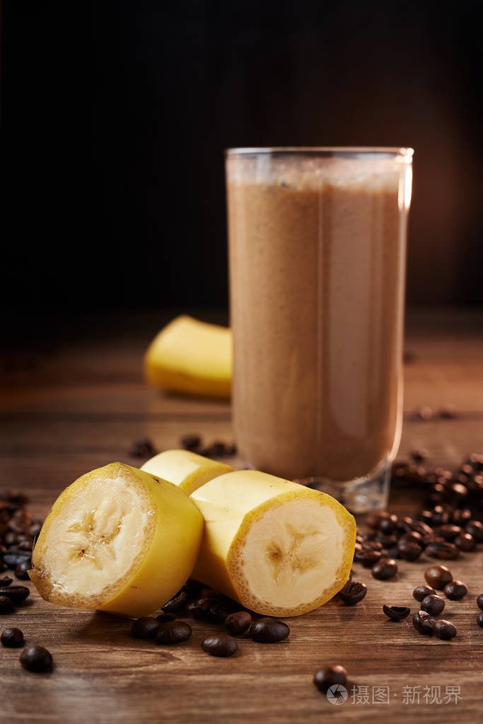 在木制的背景上一杯咖啡和香蕉奶昔