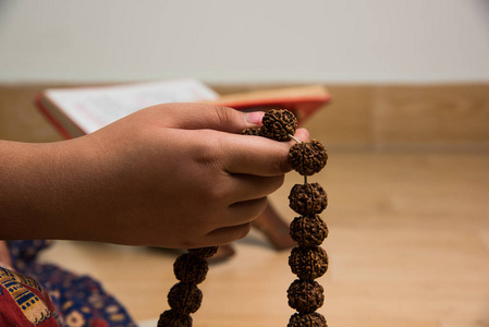 麻辣或念珠珠与宗教做冥想时的手的特写图片