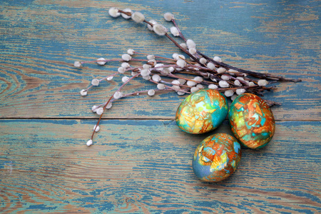 五彩缤纷的复活节彩蛋和柳条木背景上。顶视图