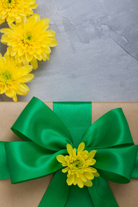 礼品盒与弓黄色菊花上灰色的具体背景