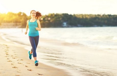 女人都参加体育运动在海滩上慢跑