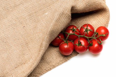 新鲜的蔬菜，樱桃番茄在麻布麻袋孤立在白色