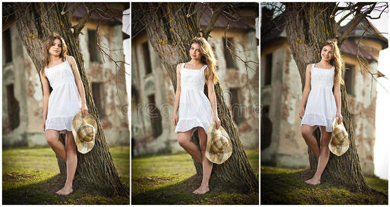 花园里一棵树旁戴着帽子的漂亮的肖像女孩。花园里穿着白色连衣裙的仙女公主。农村女孩画像