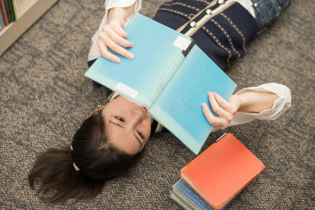 学生拿着书躺在地毯上图片