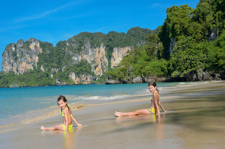 快乐的女孩们在热带海滩的海上玩耍