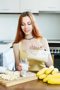 积极的女人用香蕉做奶昔