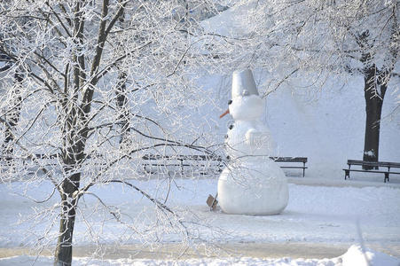 雪人在白霜覆盖的树上。