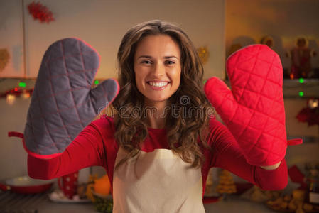 微笑的年轻主妇展示厨房手套