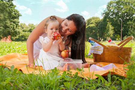 年轻快乐的妈妈带着女儿在公园野餐