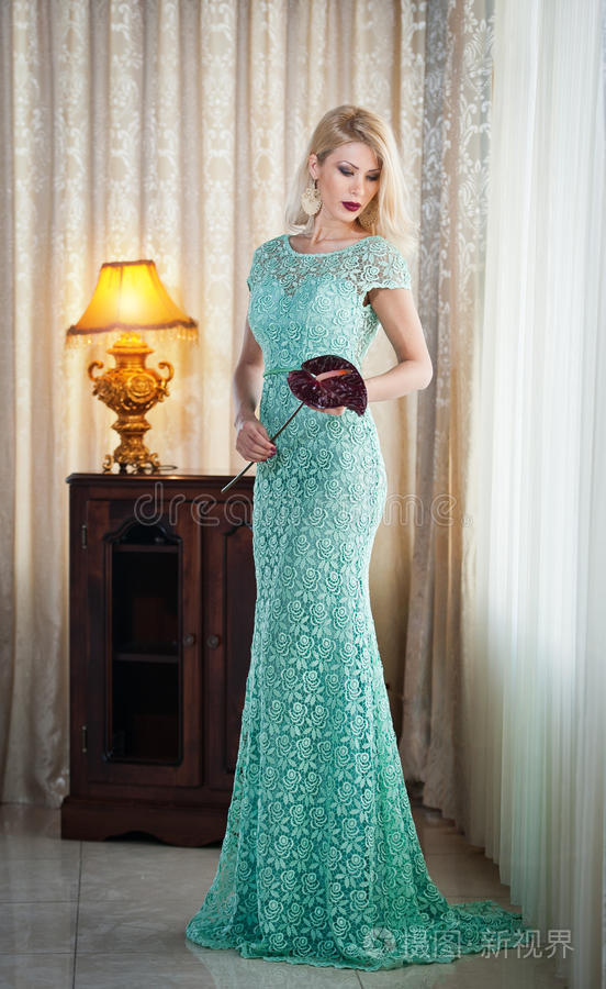 一位年轻美丽的贵妇人穿着优雅的长裙美丽的年轻金发碧绿的女人背景是