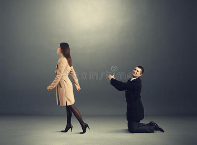 伤心的男人在女人面前弯腰照片