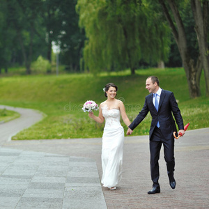 幸福的新婚夫妇一起在公园散步和玩