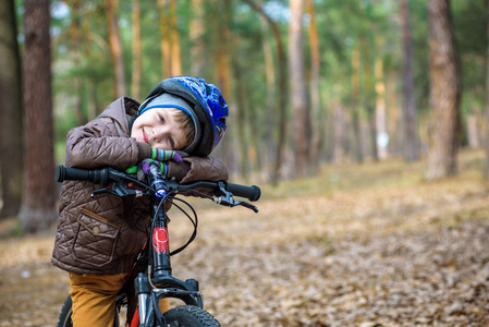 3 年或 5 年上美丽的秋季的一天，在秋天的树林，用一辆自行车开心快乐的孩子男孩。活跃的孩子戴着自行车头盔。安全 体育 休闲