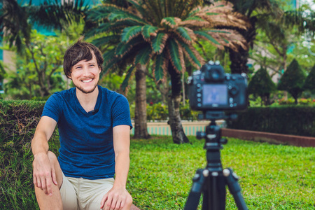 年轻男子博客记录视频摄像机在公园里
