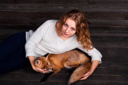 半空着一样年轻漂亮的女孩抱着一种野生狐狸动物,是一个人的精神创伤