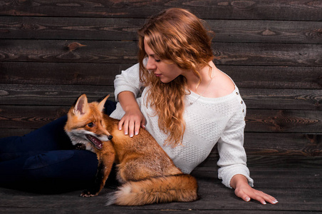 年轻漂亮的女孩抱着一种野生狐狸动物，是一个人的精神创伤，救起她现在像以前一样生活