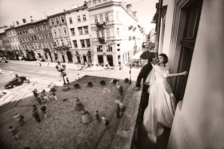 时尚婚礼情侣亲吻在旧城的阳台上