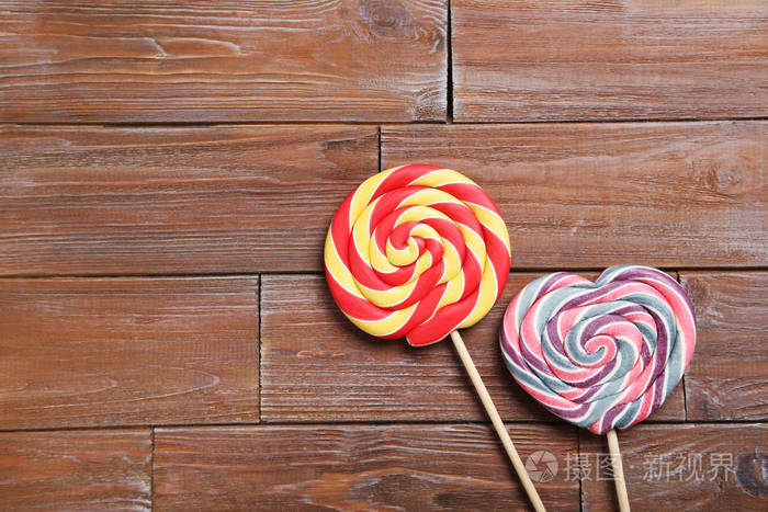 在褐色的木桌上的甜棒棒糖
