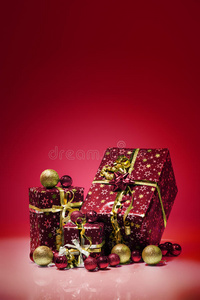 礼品盒和圣诞球，隔离在红色背景上