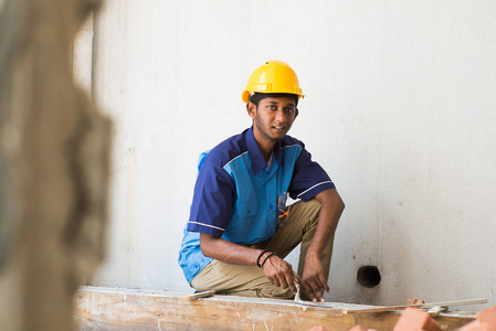 建筑工人安装砖块建筑房屋的特写在白色的陶艺工具在工地上安装砖的