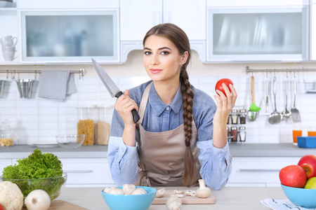 烹饪概念。厨房里有刀的少妇