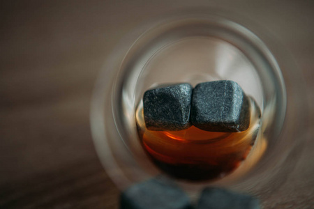 冷却威士忌的石头和在加克木制背景上的糖