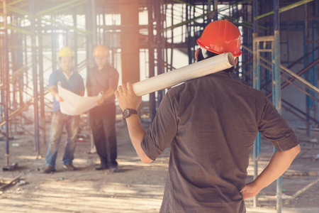 建设概念，工程师和建筑师在建筑地盘工作与蓝图