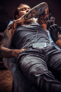 纹身专家展示制作过程中的纹身在纹身店