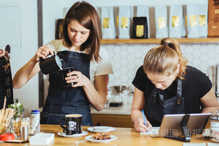 两个女店员在背后的 coutner 咖啡厅工作.