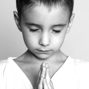 祷告。美丽的小男孩特写肖像。黑白照片