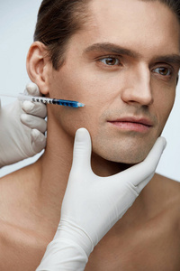 整形手术。英俊的男人在脸上的皮肤接受注射