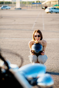 蹲在她的摩托车后面有魅力的女人骑自行车的人