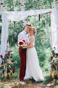 年轻美丽的夫妇，新娘和新郎在森林里。婚礼装饰背景
