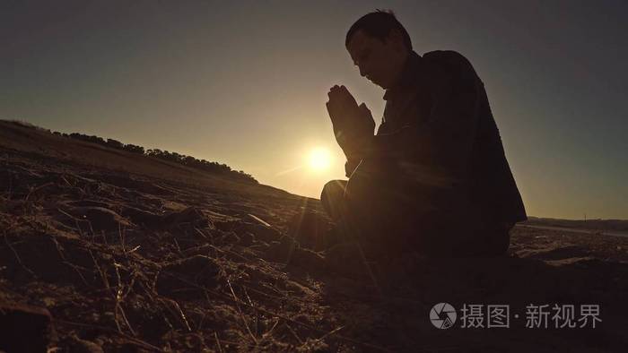 男人坐剪影阳光宗教祈祷日落神