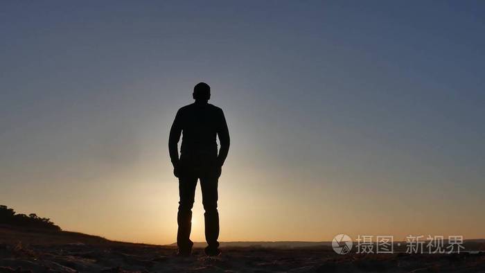 自由.男人站在悬崖上落日下的剪影手的生活方式双方