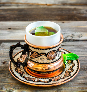与在木制的桌子上的阿拉伯风格的薄荷茶