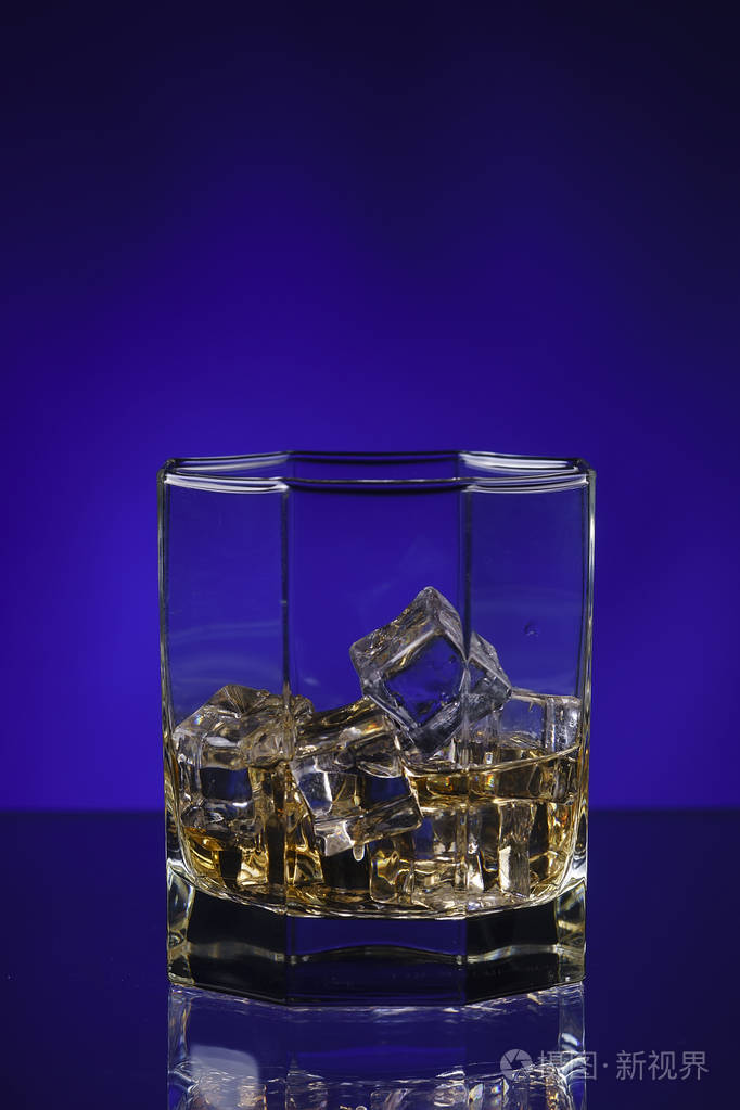 杯威士忌加冰蓝色背景上