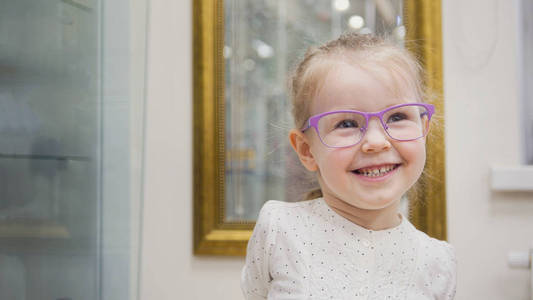 金发碧眼的小女孩，微笑着的眼镜和戏剧在眼科临床中